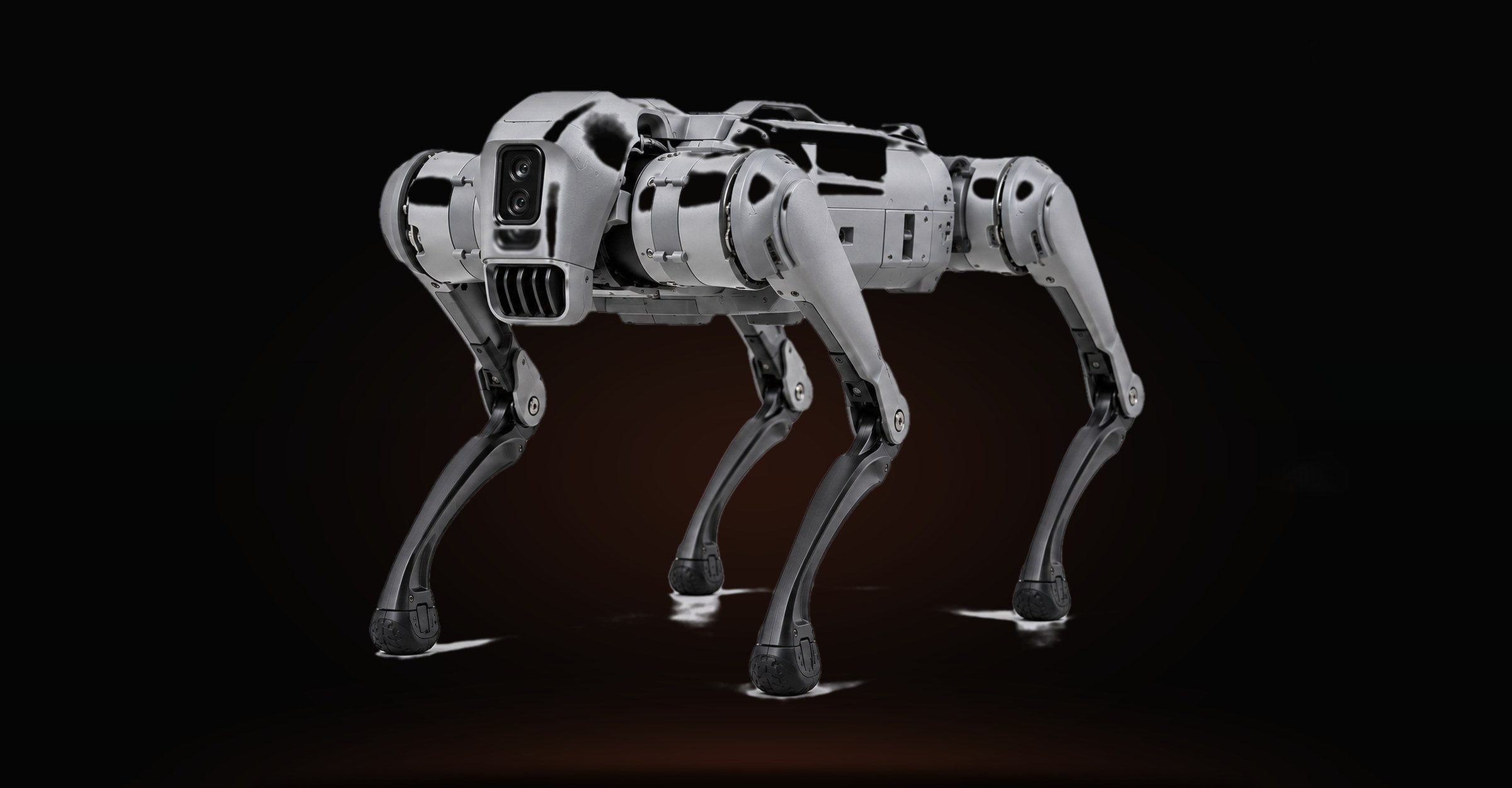 Rex, a quadruped robot, standing lit against darkness.